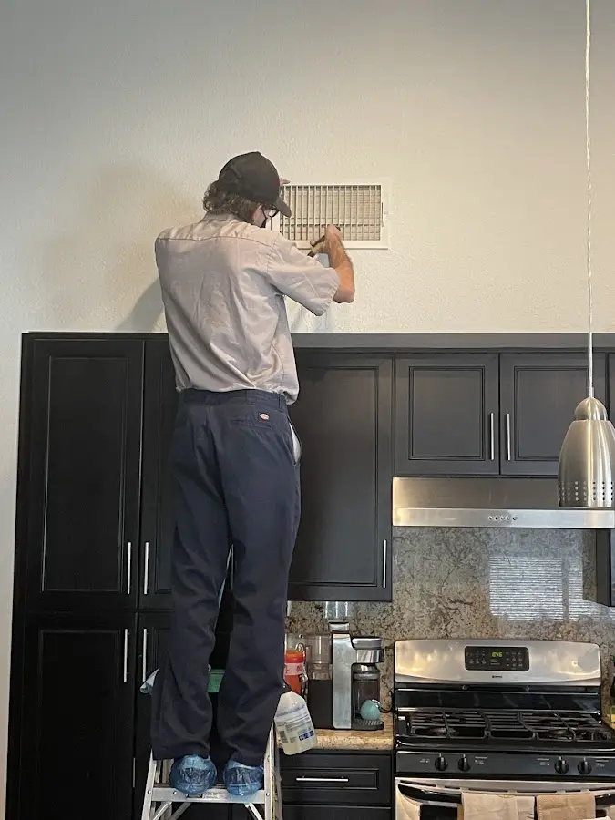 Technician inspecting an air vent during HVAC service in Catskill